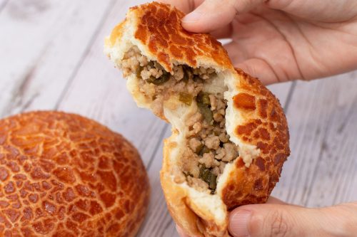 bread secret hand splitting a peeled chilli pork bun