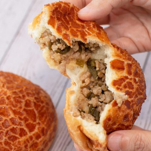 bread secret hand splitting a peeled chilli pork bun